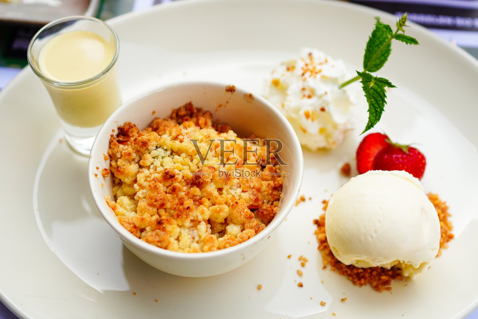 自制苹果酥，香草冰淇淋，草莓和奶油蛋羹放在桌上照片摄影图片