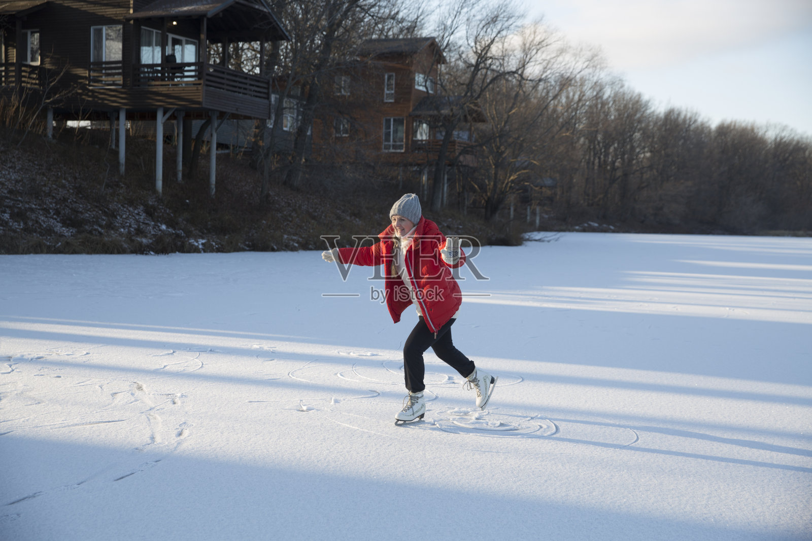 快乐的老年妇女在冬季自然结冰的湖上滑冰。享受小事。冬天的共鸣。圣诞假期照片摄影图片