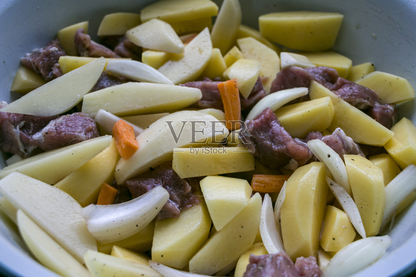 生土豆，洋葱，胡萝卜和猪肉。烹饪。照片摄影图片