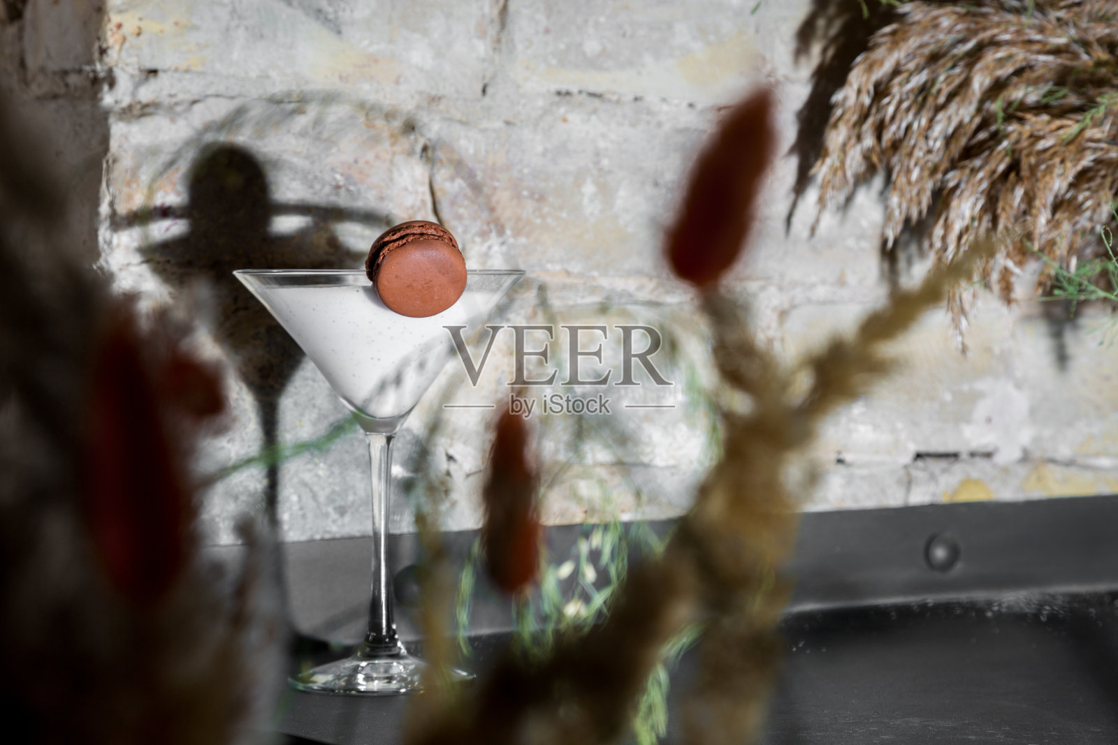 在砖墙背景的桌子上，有一杯奶昔和通心粉照片摄影图片