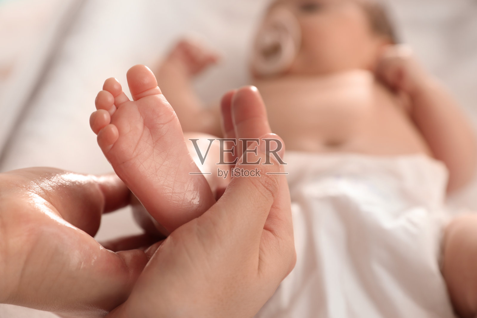 妈妈用油给她可爱的宝宝按摩，特写照片摄影图片