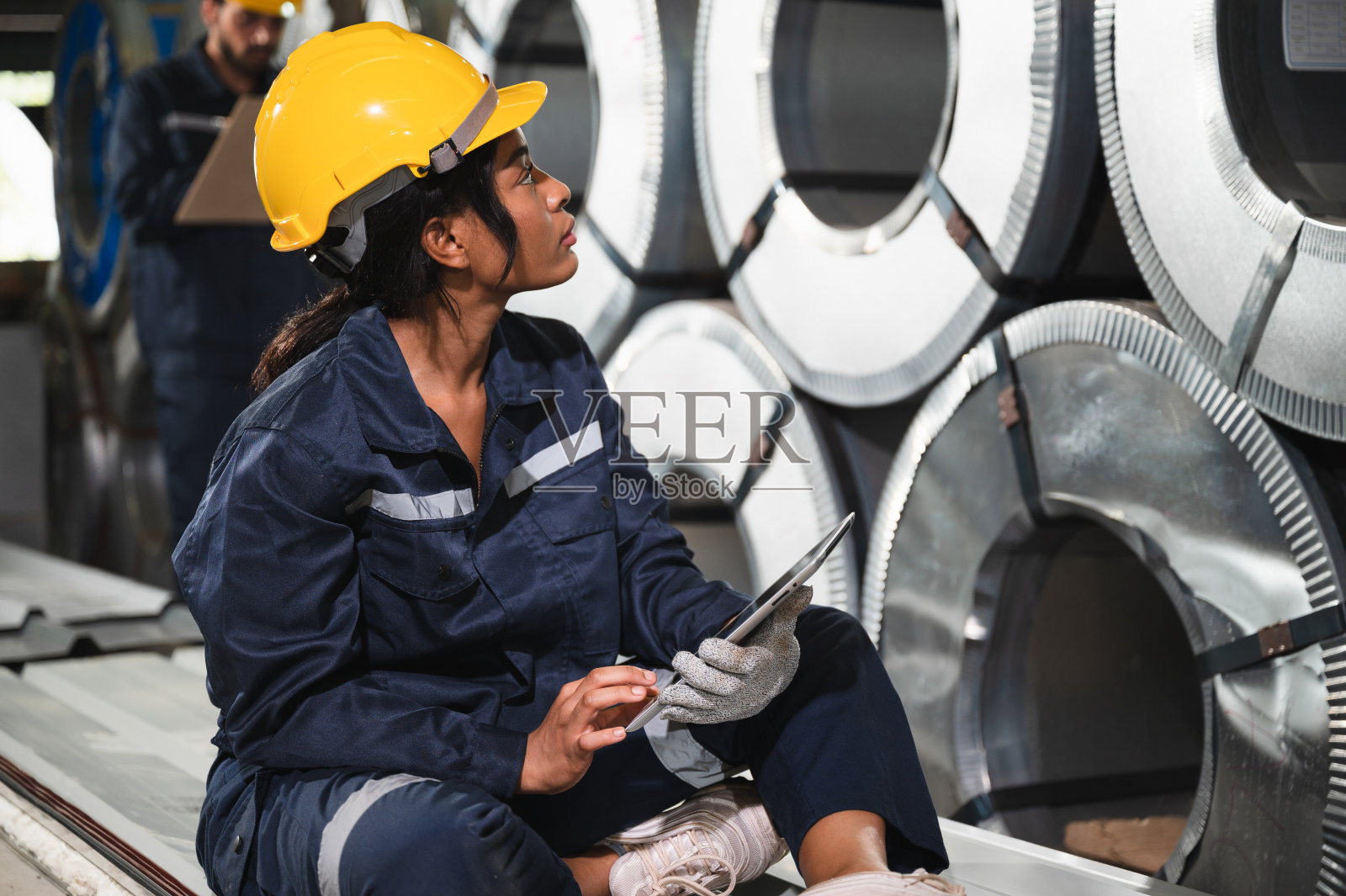 肖像非裔美国工程师妇女拿平板电脑与金属板在工厂照片摄影图片