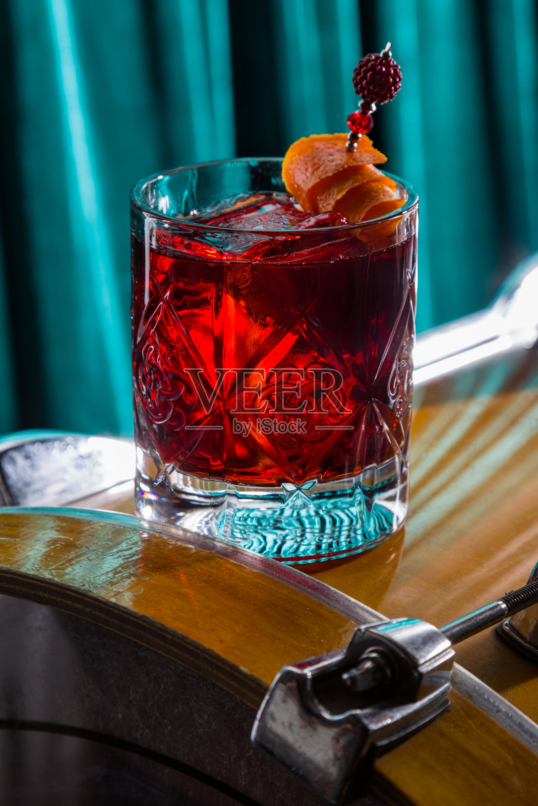 鸡尾酒加冰，橘子皮串在桌上的玻璃杯里照片摄影图片