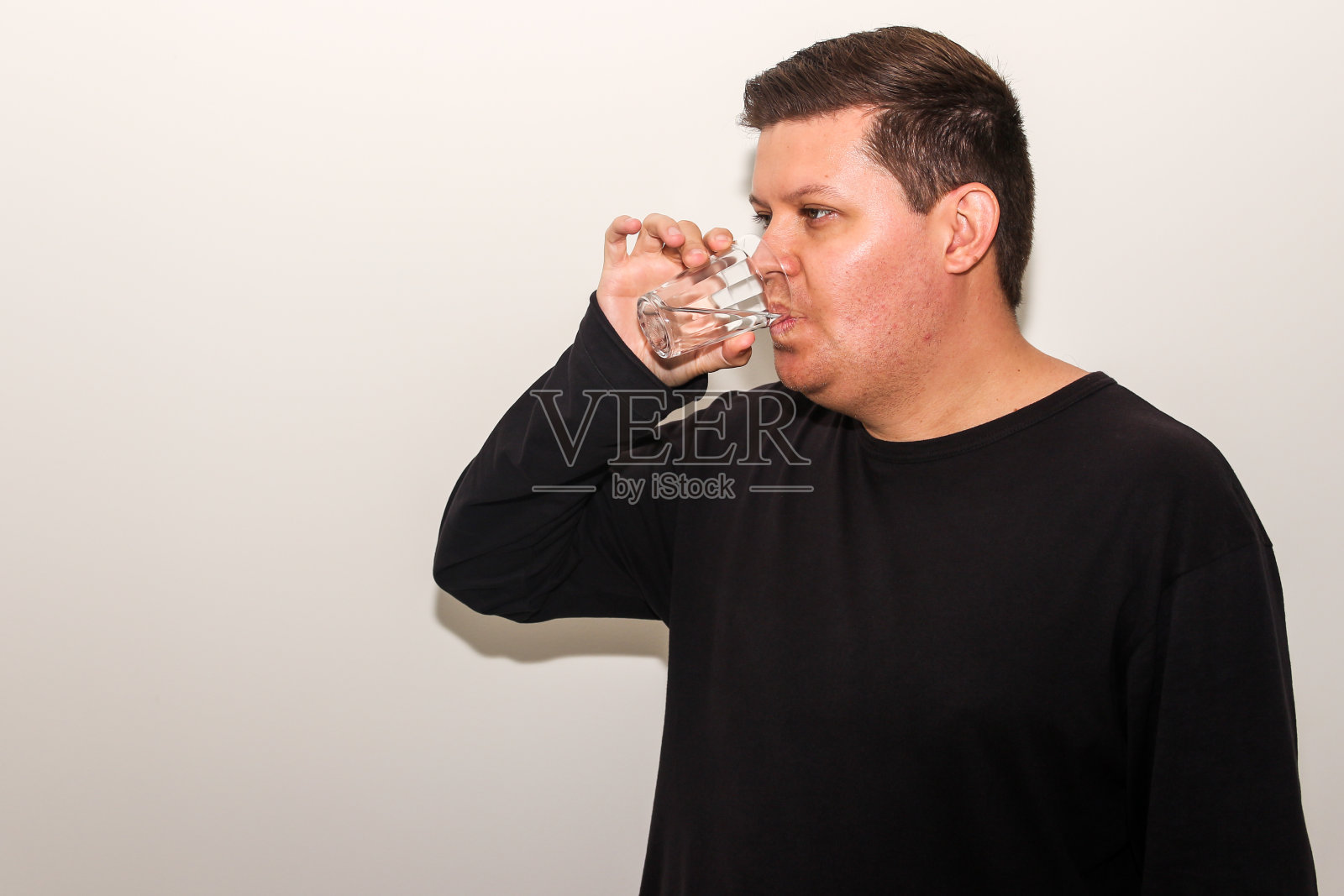 穿黑衬衫的巴西人喝水照片摄影图片