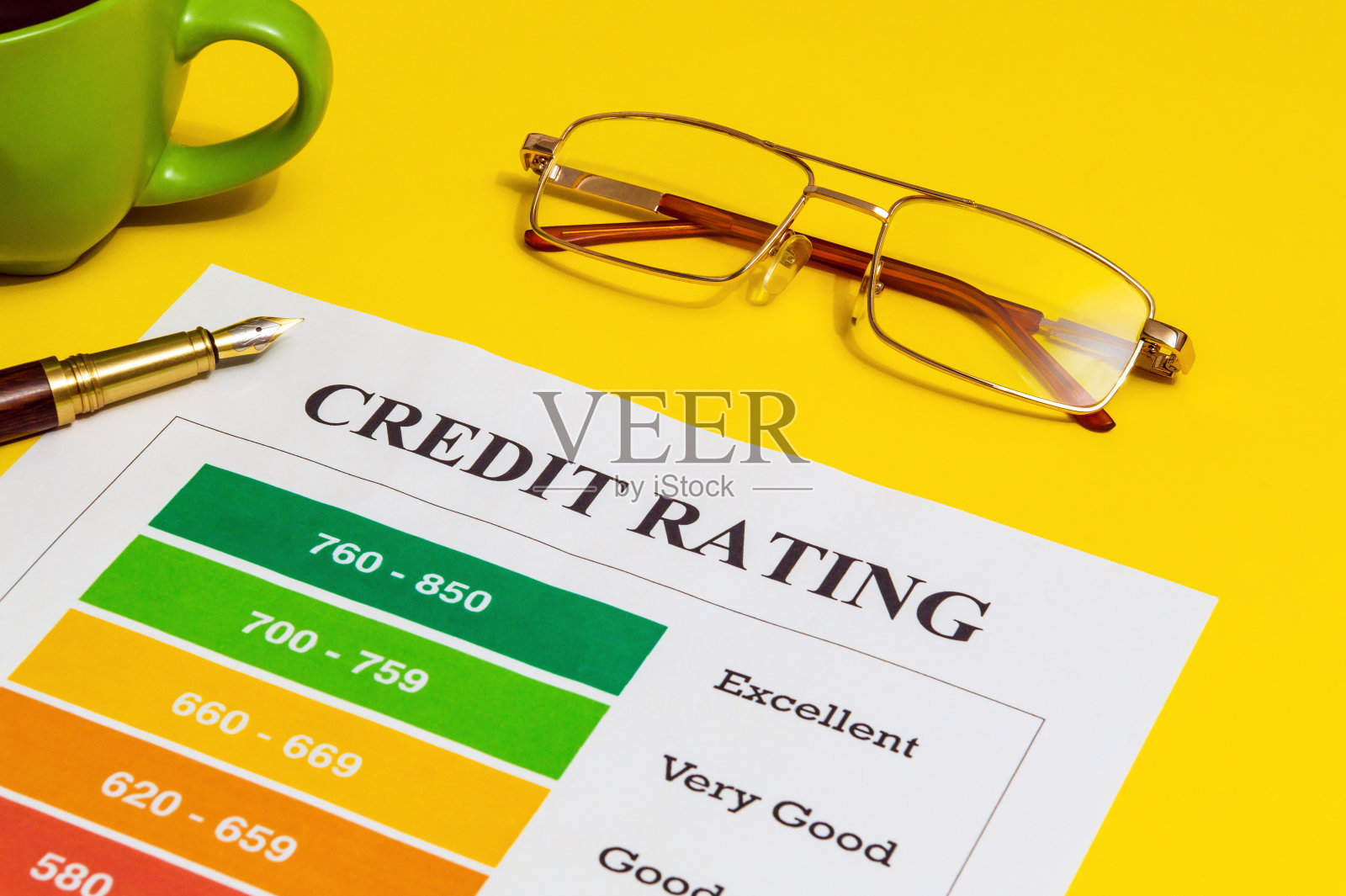 信用评级在一张黄色的办公桌上，还有笔和眼镜照片摄影图片