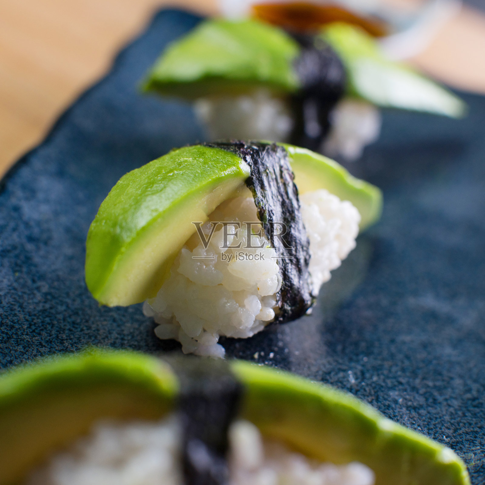 绿色牛油果素食握寿司。素食日本料理。照片摄影图片