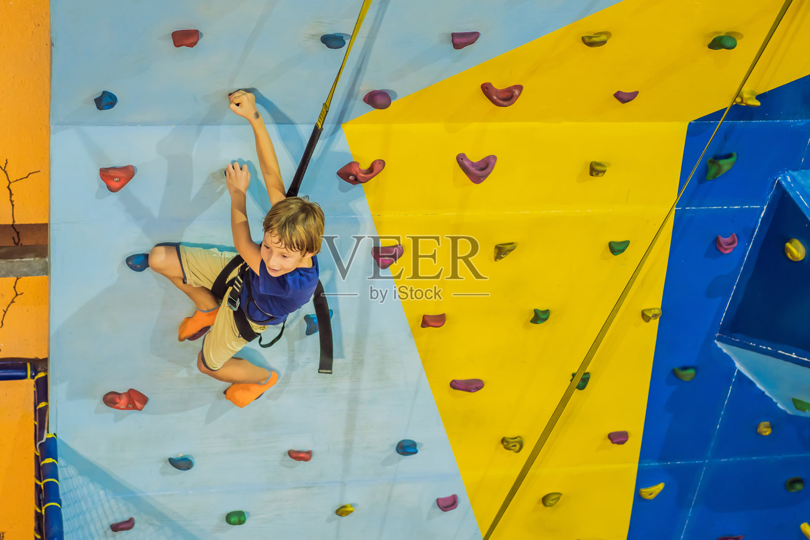 一个6岁的孩子在攀岩中心的墙上攀岩照片摄影图片
