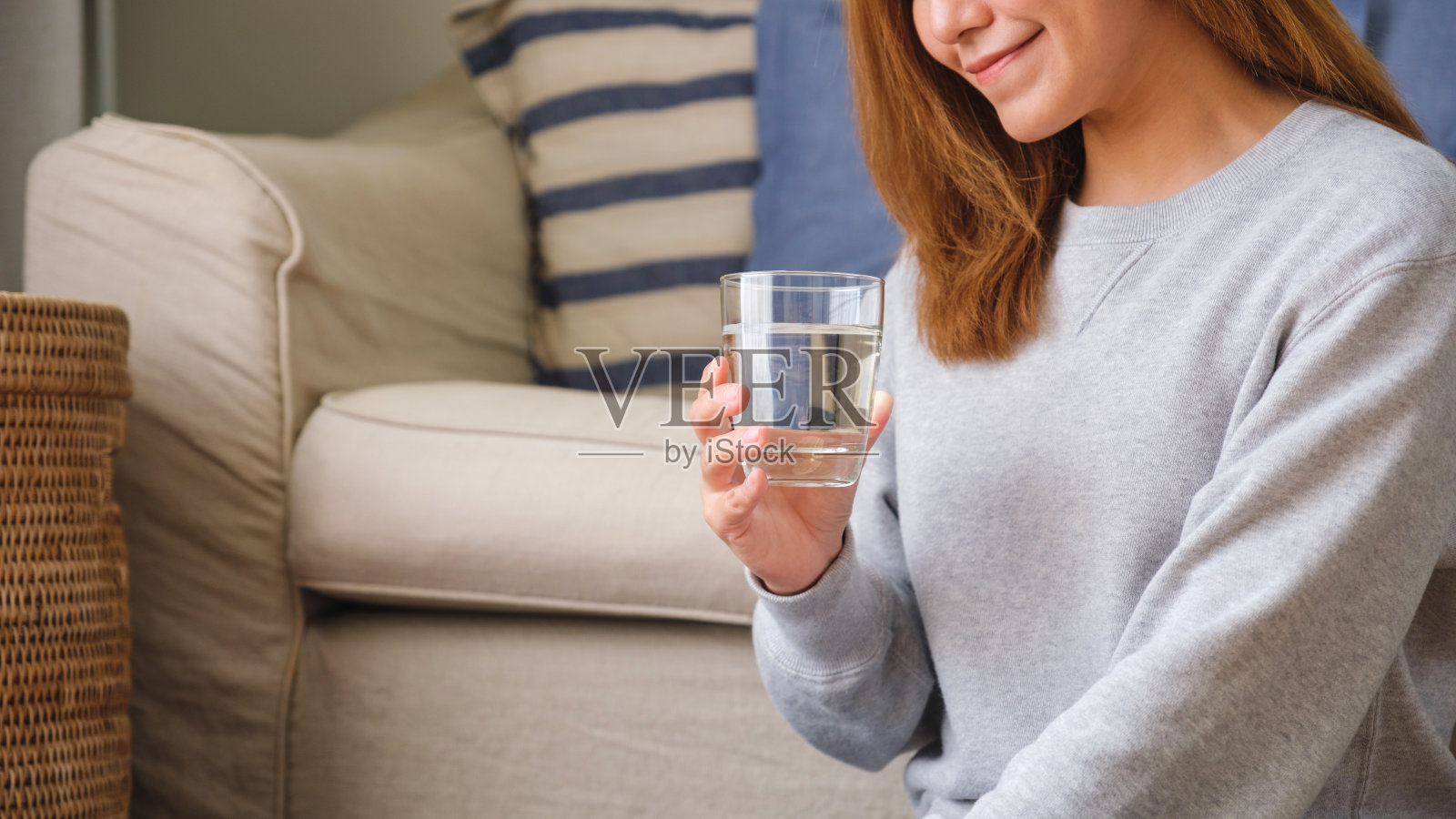 一个年轻女子拿着一杯水喝水的特写图像照片摄影图片