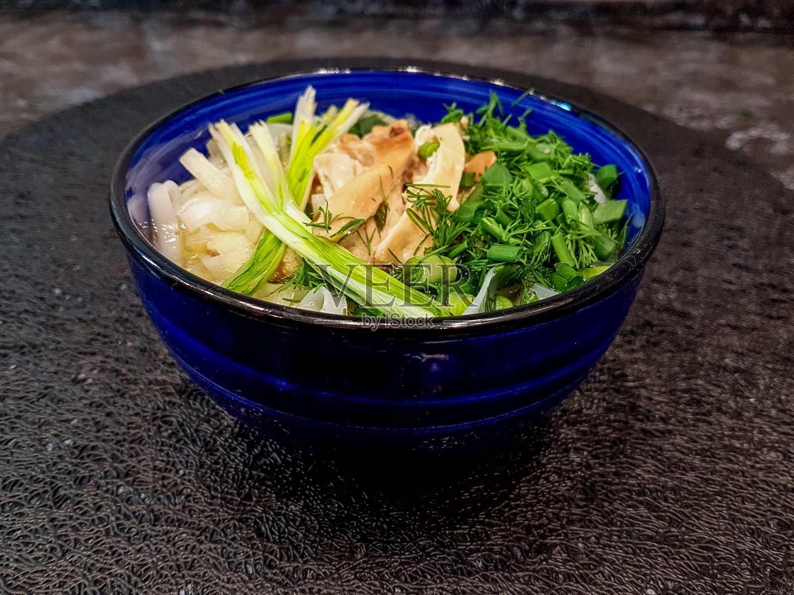 传统的河粉汤，牛肉，米粉，生姜，柠檬在碗里，黑色的背景。越南菜和亚洲菜。照片摄影图片