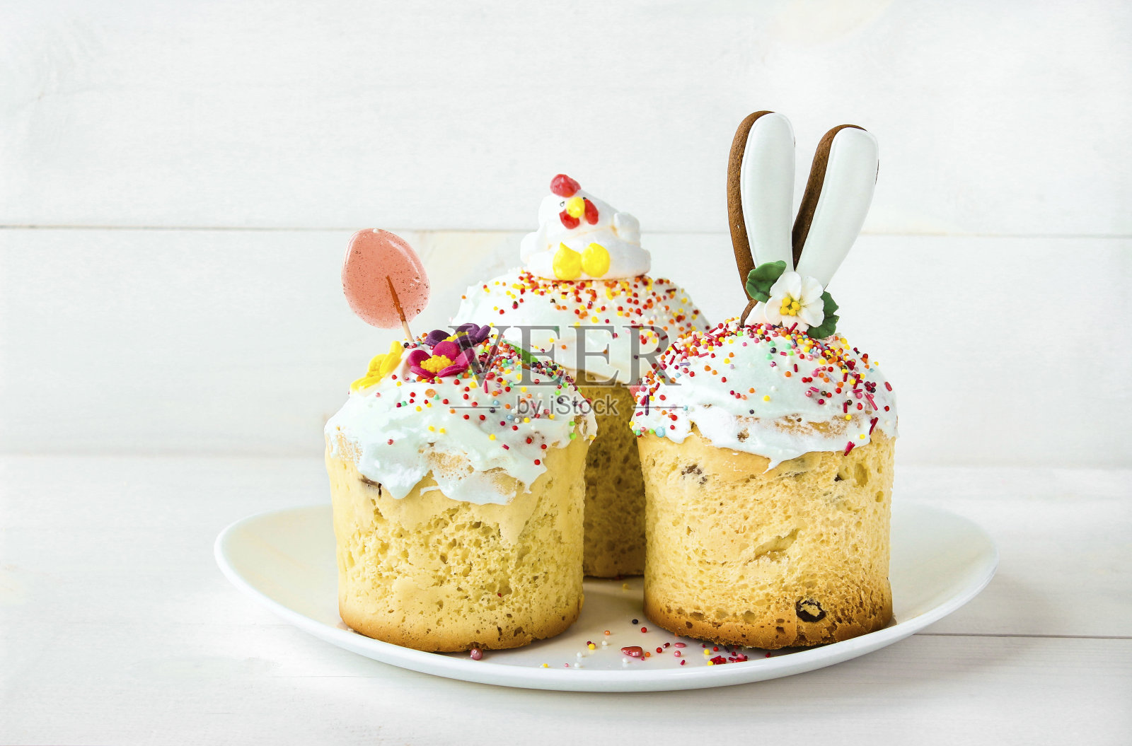 白色木色背景上的白色盘子里放着三块复活节蛋糕。传统的基督教复活节糕点。最小的复活节作文与文本的地方。快乐复活节概念照片摄影图片