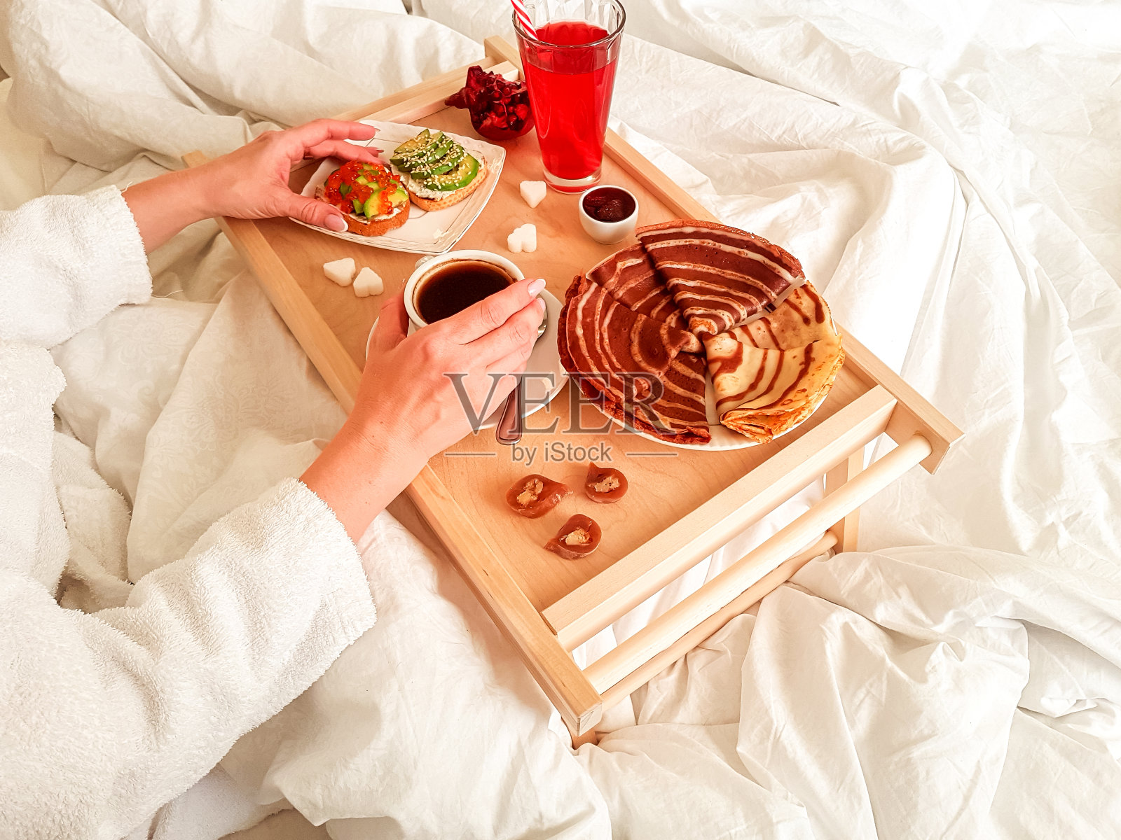 休息日卧室床上的木制早餐桌。照片摄影图片