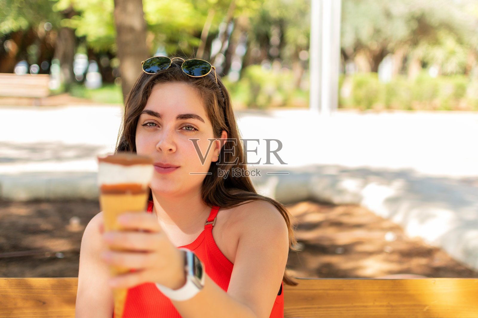 年轻的女孩手里拿着甜筒冰淇淋照片摄影图片