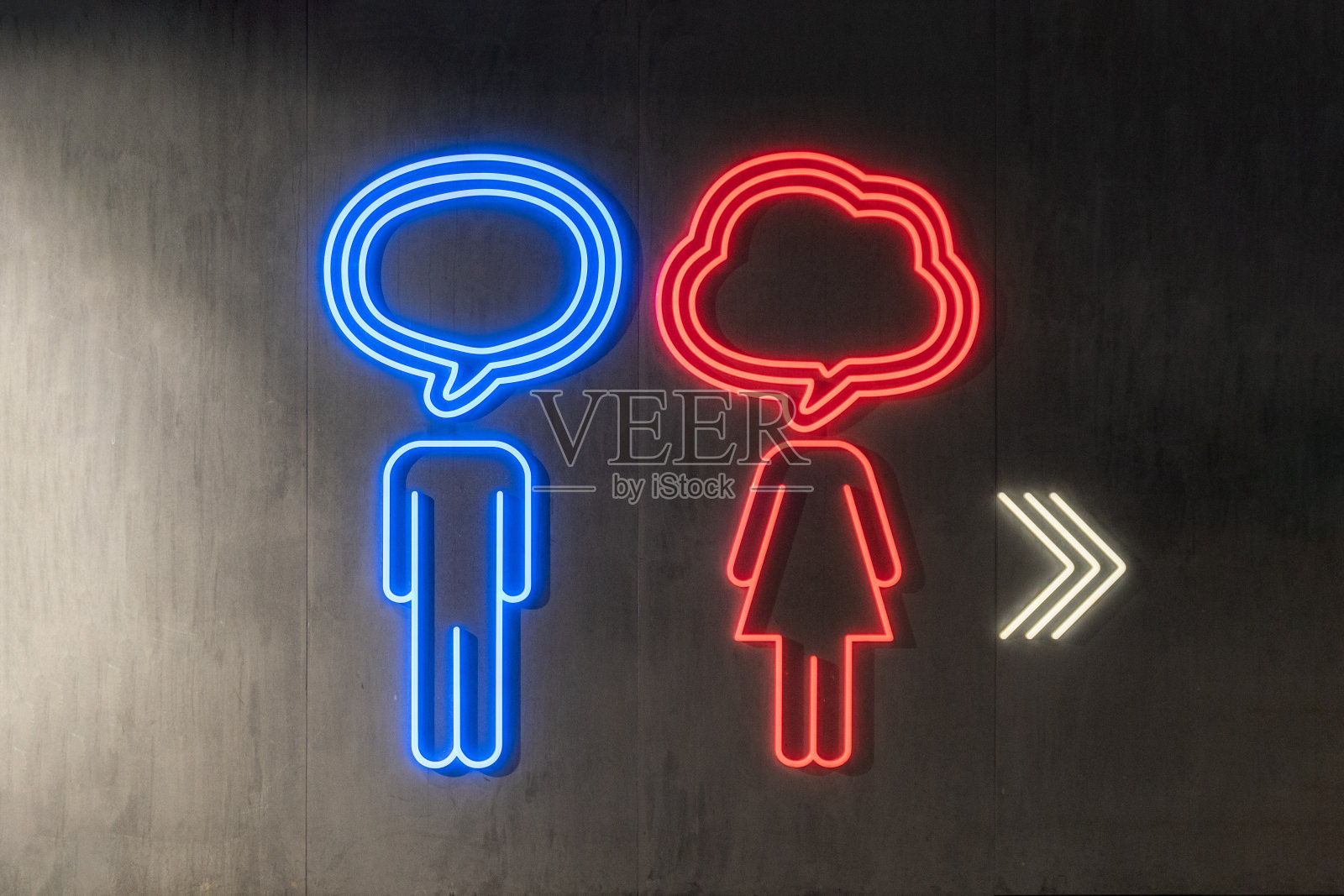 照明厕所霓虹灯标志与箭头符号在黑暗的墙壁背景照片摄影图片