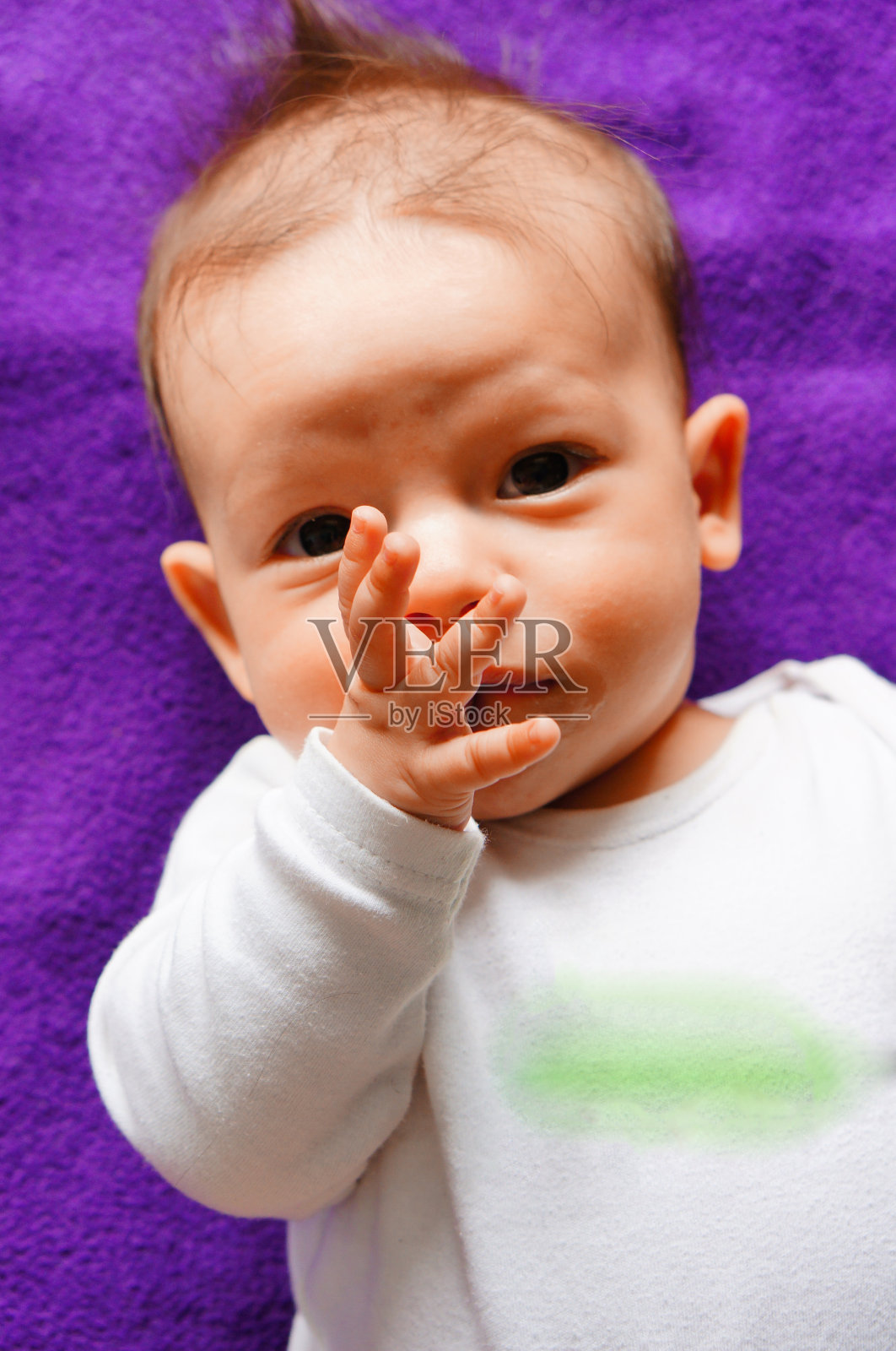 白人男孩躺在紫色毯子上照片摄影图片