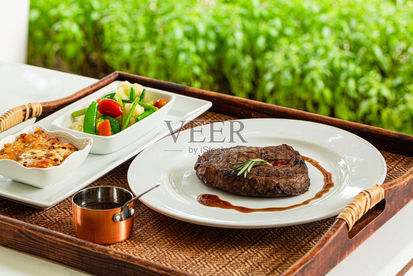 牛排放在桌上的盘子上，侧视图切烤牛排肋眼牛排和土豆放在白色盘子上照片摄影图片