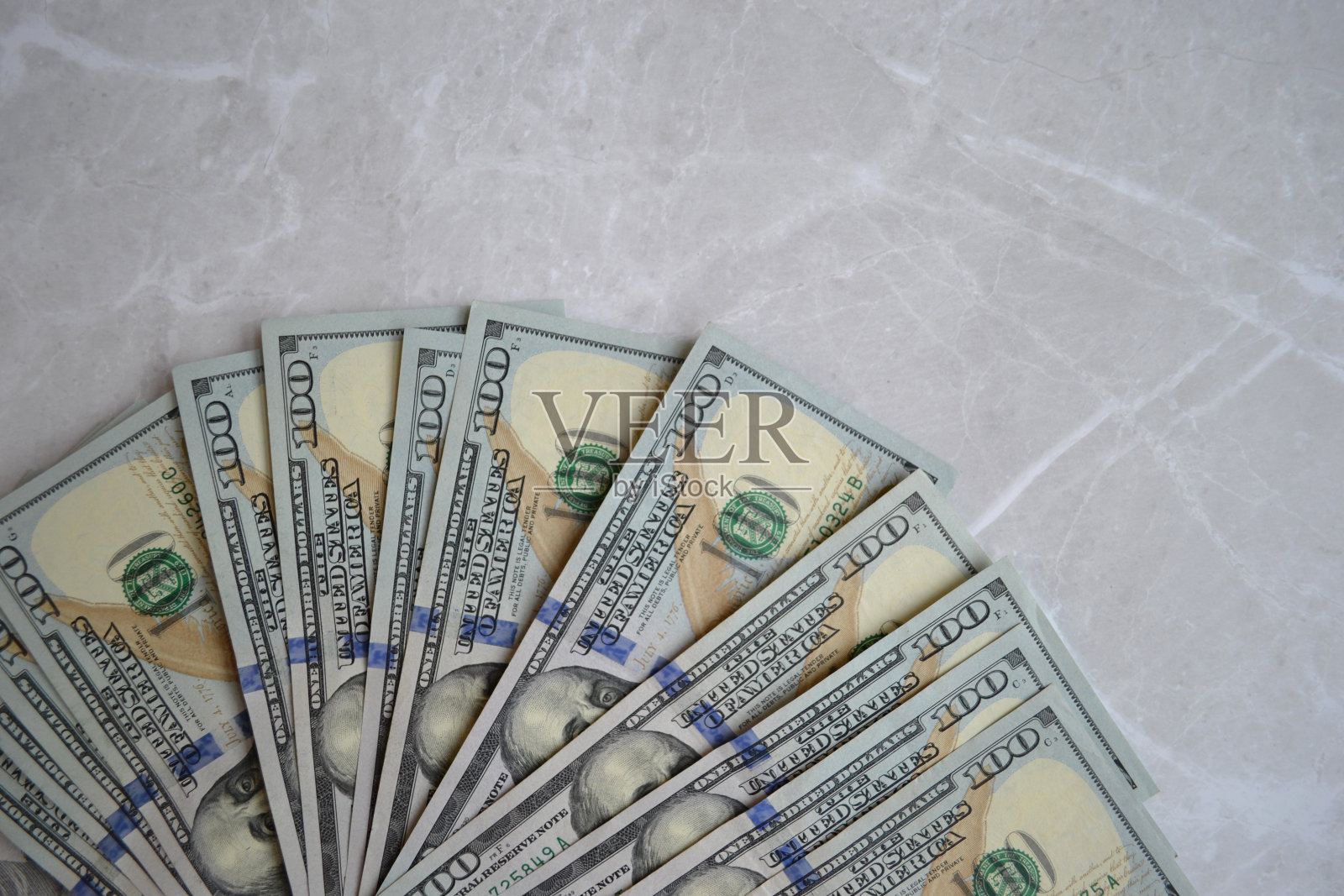 几张百元美钞在白色大理石表面呈扇形散开照片摄影图片