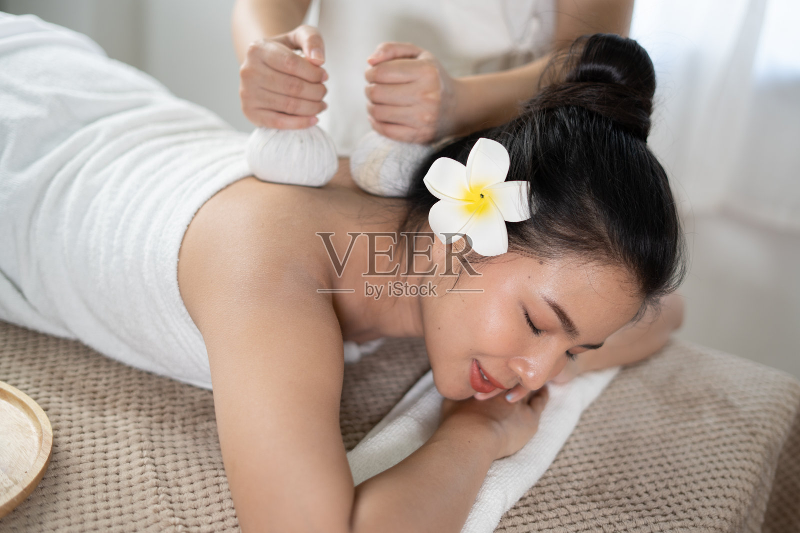 年轻的亚洲美女享受按摩和水疗。照片摄影图片