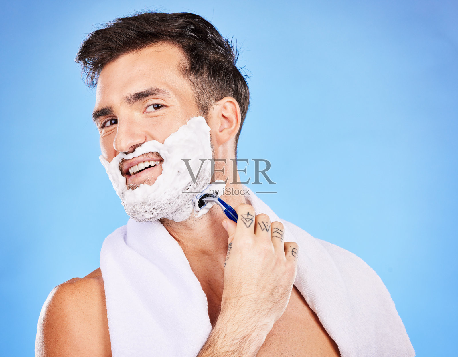 面部，剃须和脱毛与一个男人模型剃须他的皮肤在工作室上的蓝色背景的健康或卫生。画像，胡须和剃须刀与一个年轻的男性单独在浴室梳妆照片摄影图片