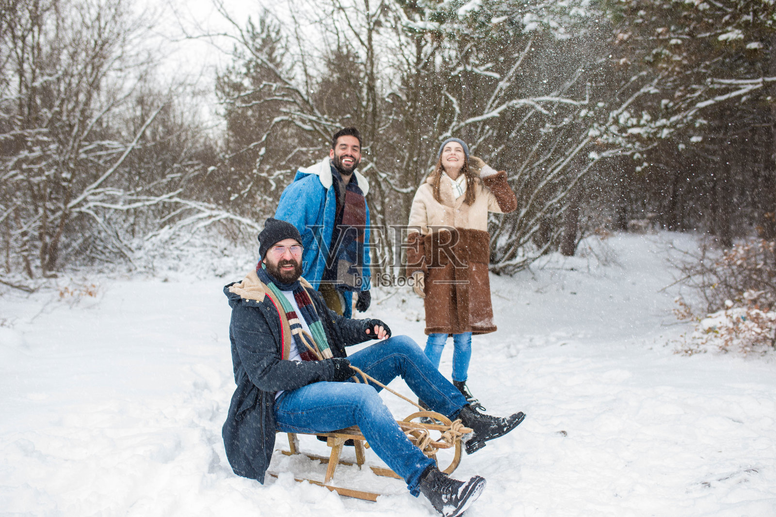 一群朋友在下雪的冬天玩雪橇照片摄影图片