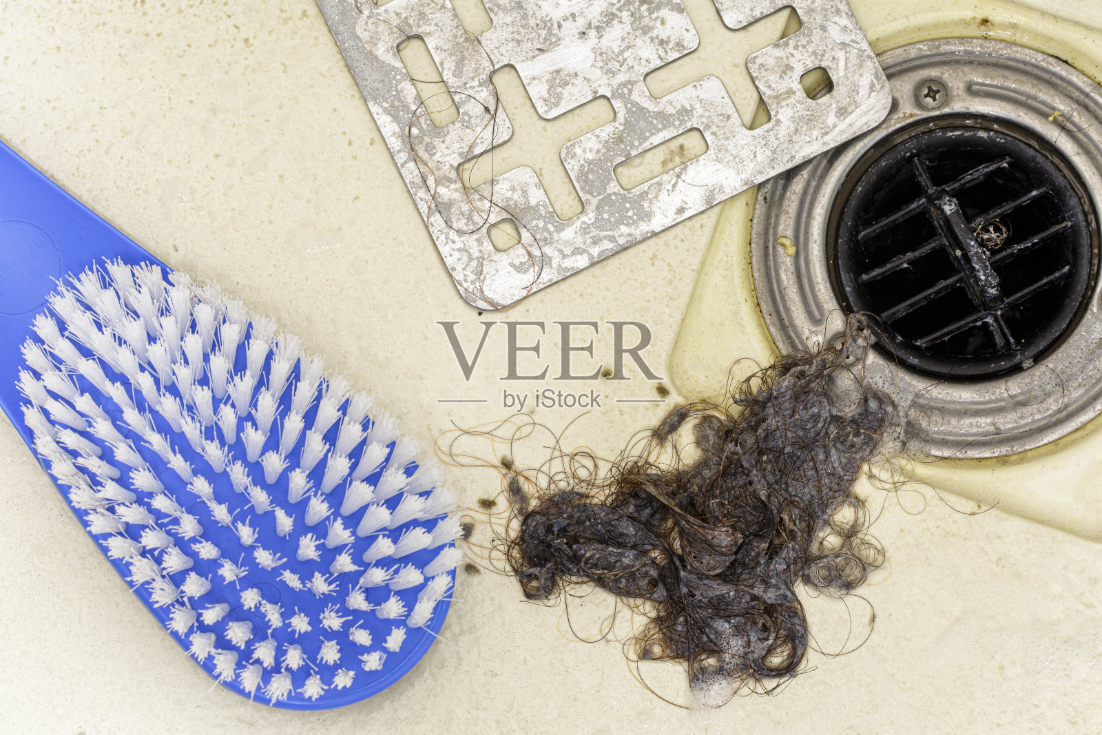 从淋浴排水管中收集的头发残渣、肥皂渣和污垢照片摄影图片