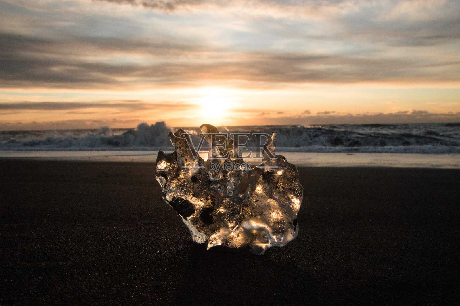 冰晶部分冰山冰川碎片在黑沙海浪日落钻石海滩Jokulsarlon冰岛南部照片摄影图片