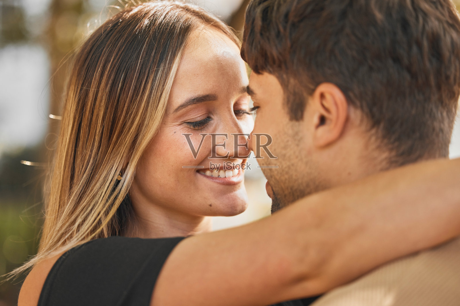 情侣，在户外幸福地拥抱和爱，浪漫地拥抱和触摸鼻子。幸福，信任和浪漫的拥抱，男人和女人的微笑在婚姻或约会关系。照片摄影图片