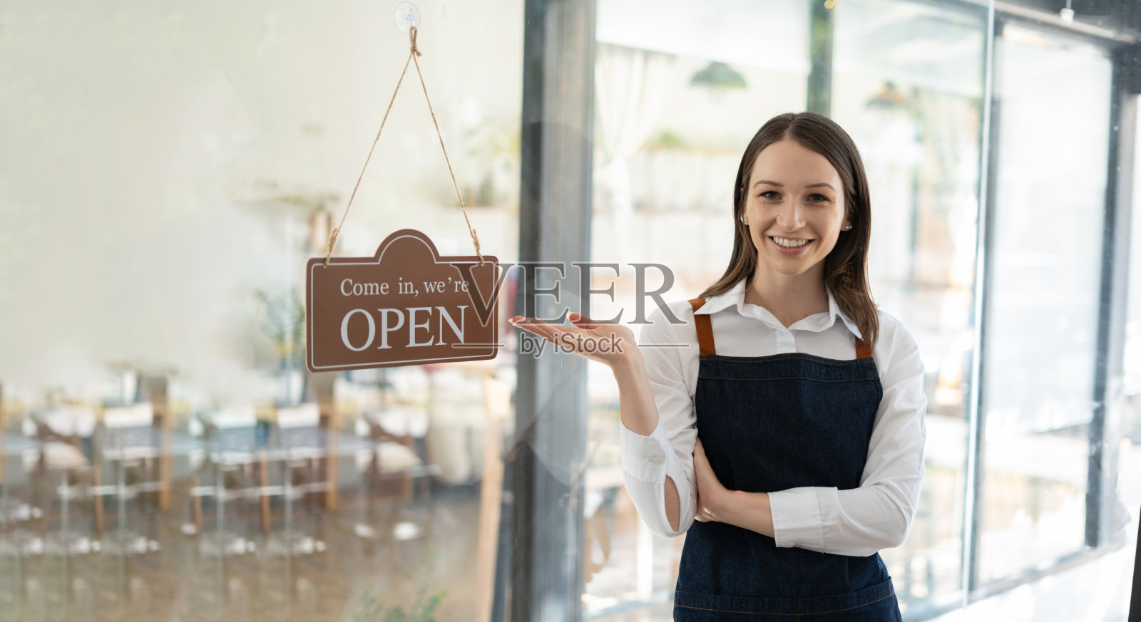 小本生意：围裙女士在咖啡店吧台旁照片摄影图片