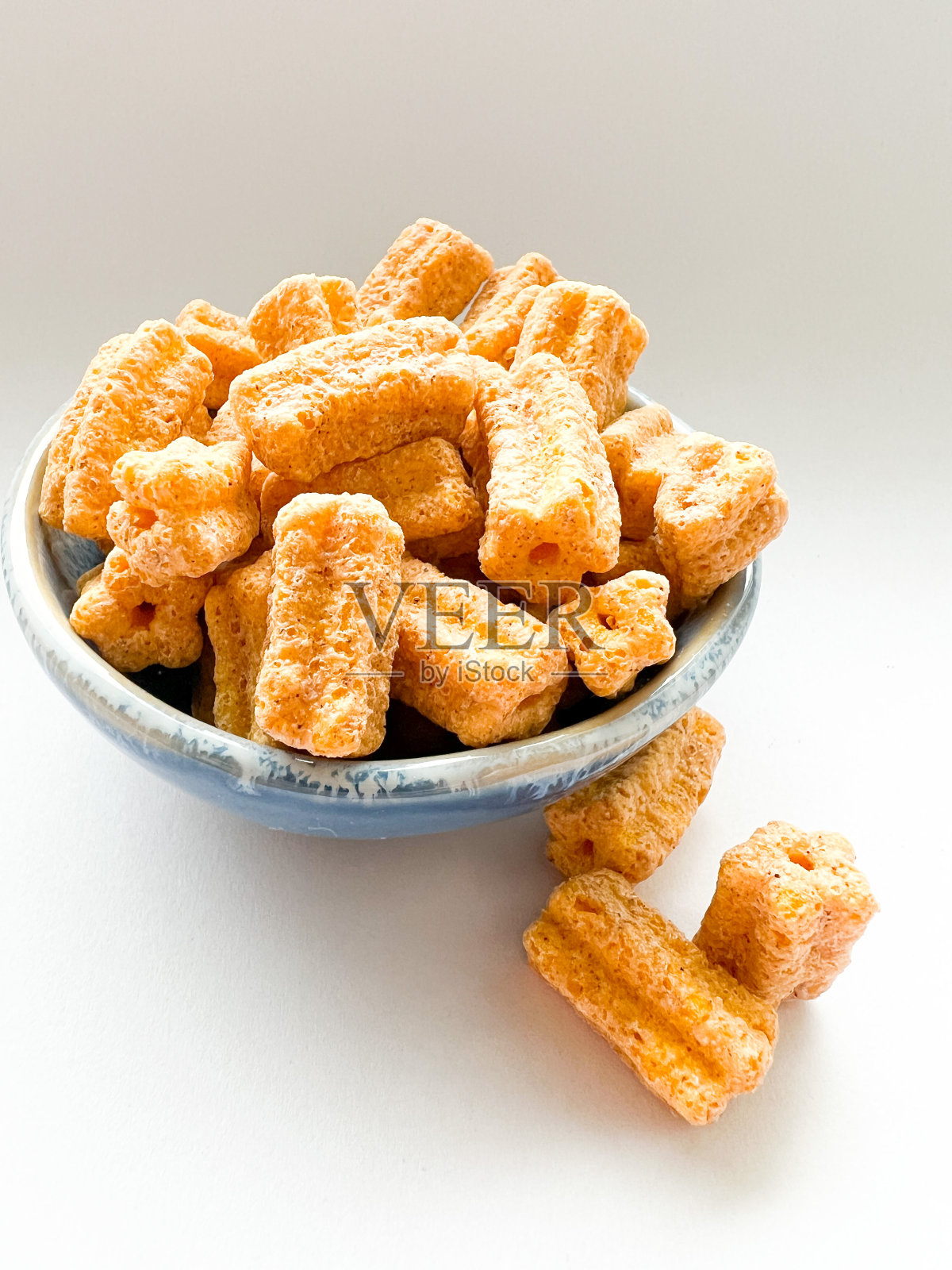 白色背景的小碗里的迷你油条麦片照片摄影图片