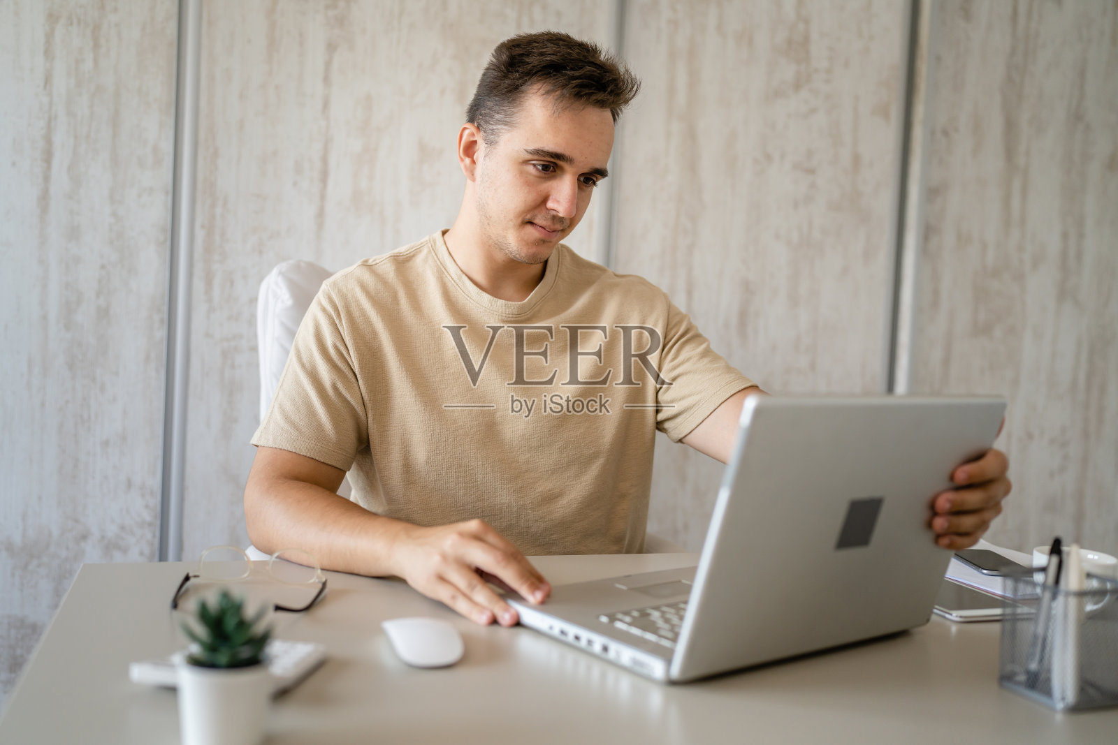 一名年轻的白人男性在办公室用笔记本电脑工作照片摄影图片