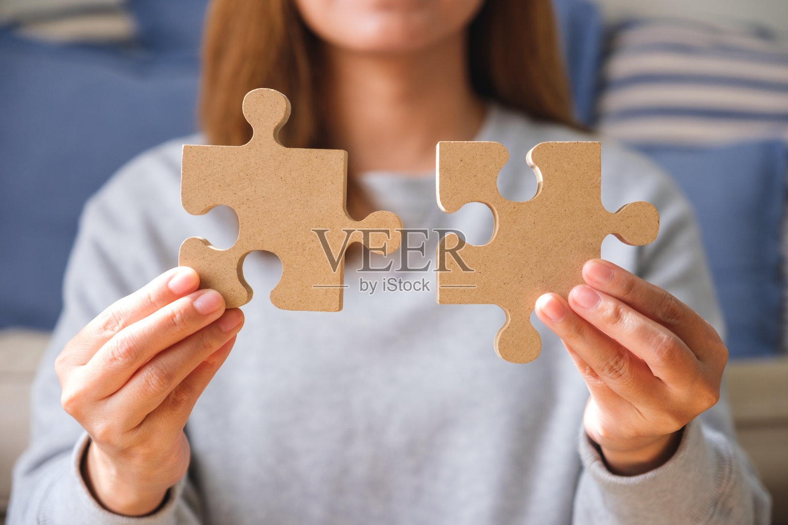 一个女人拿着一块木制拼图拼在一起的特写图像照片摄影图片