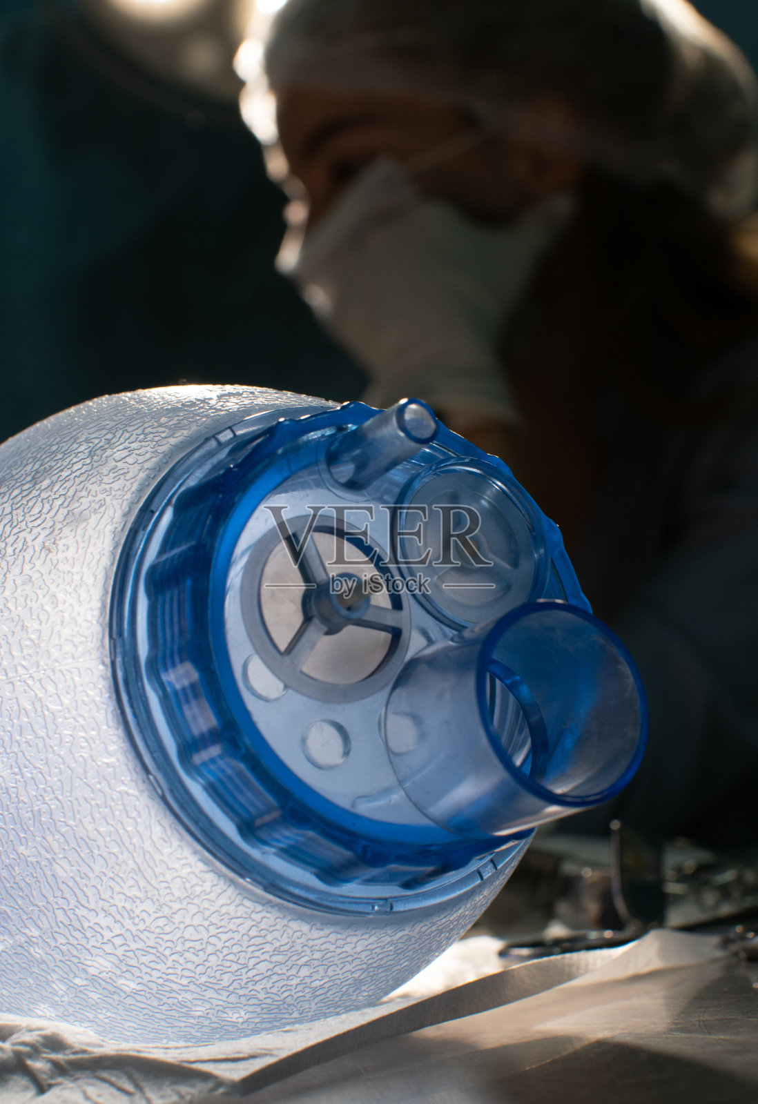 救护包的漂亮特写，背景是一位正在做手术的医生。在手术室里，氧气袋放在外科医生的背景上。底部视图。照片摄影图片