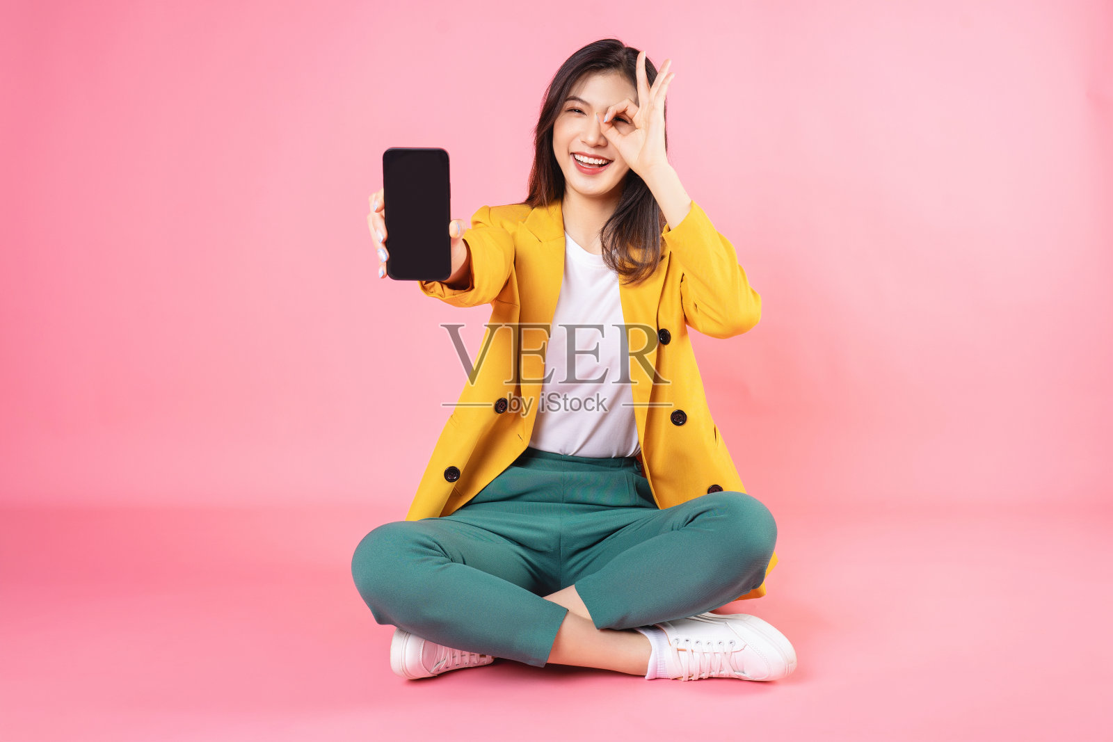 年轻的亚洲女商人坐在背景上拿着智能手机的图像照片摄影图片