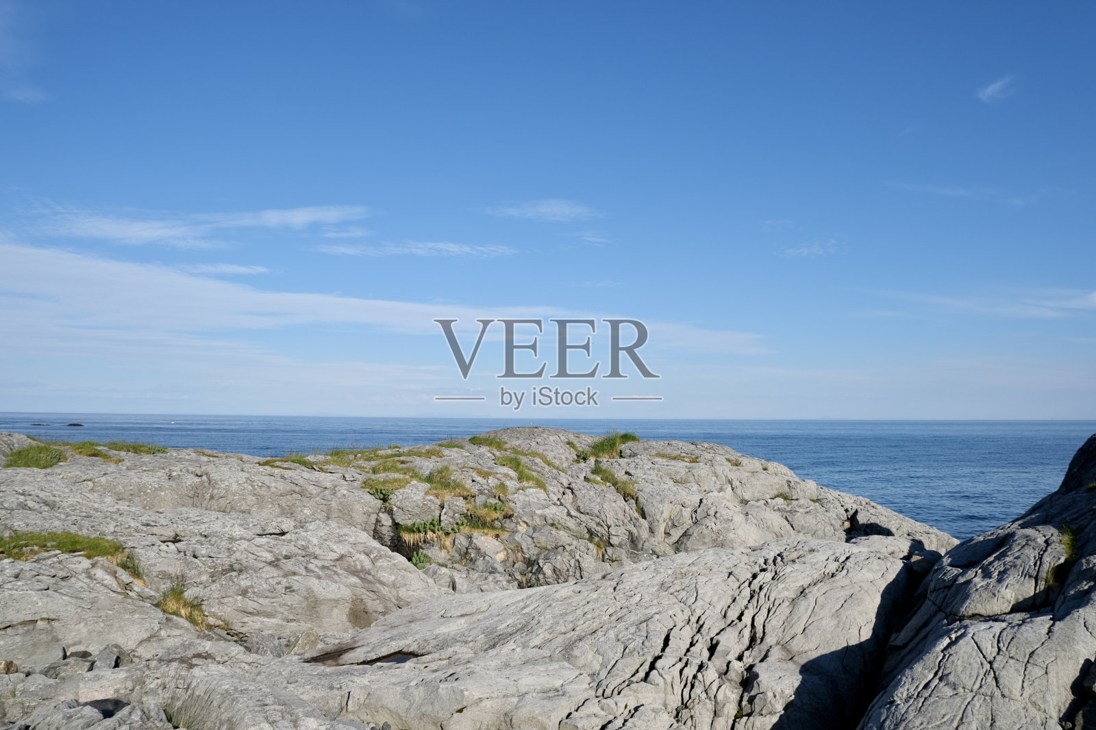 海岸岩石密布的海湾，多云的天空照片摄影图片