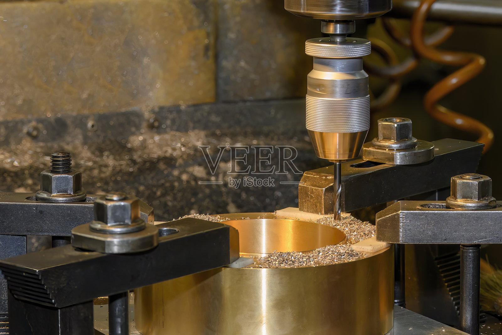 黄铜材料在数控铣床上的钻削过程。照片摄影图片