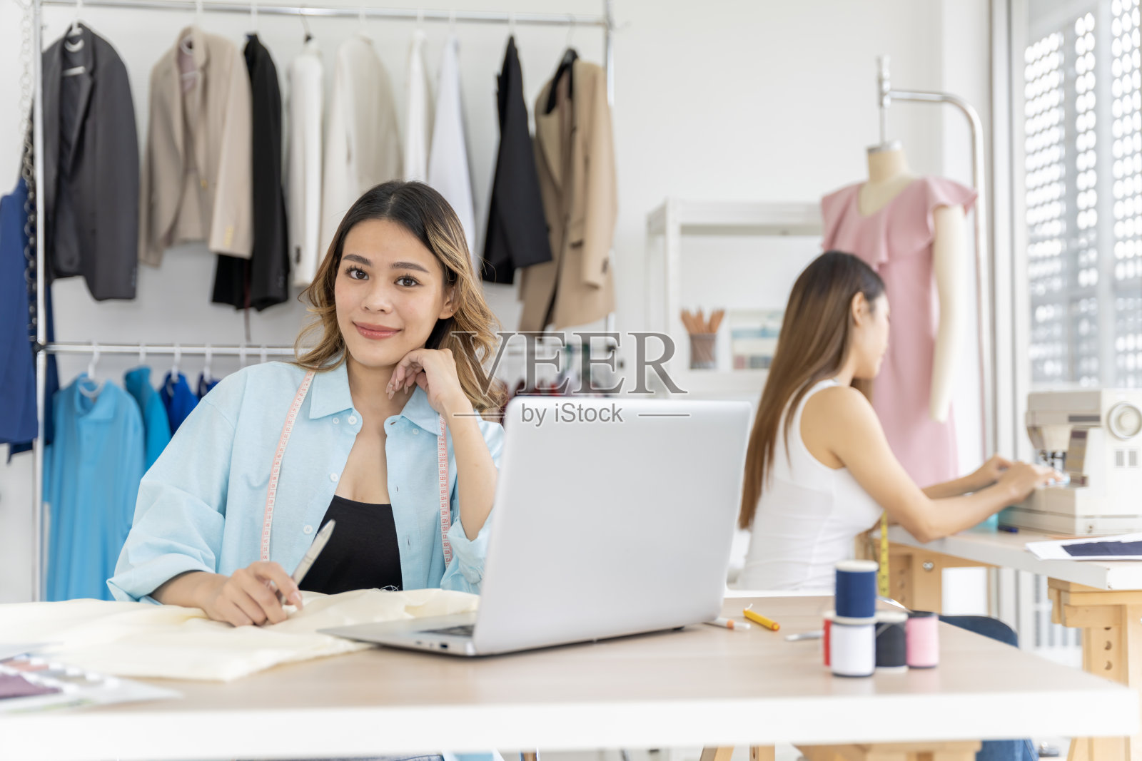 两个亚洲女人一起做小生意，中小企业，为客户定制设计。他们都是伟大的设计师。照片摄影图片