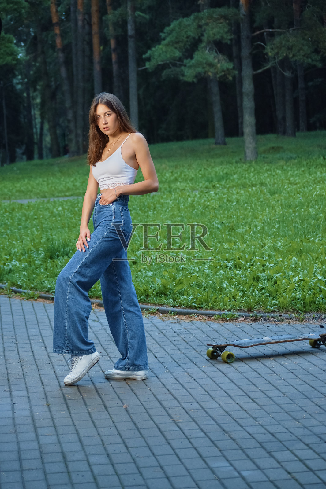 一个穿着牛仔裤和白色上衣的美丽白俄罗斯女孩的特写照片摄影图片