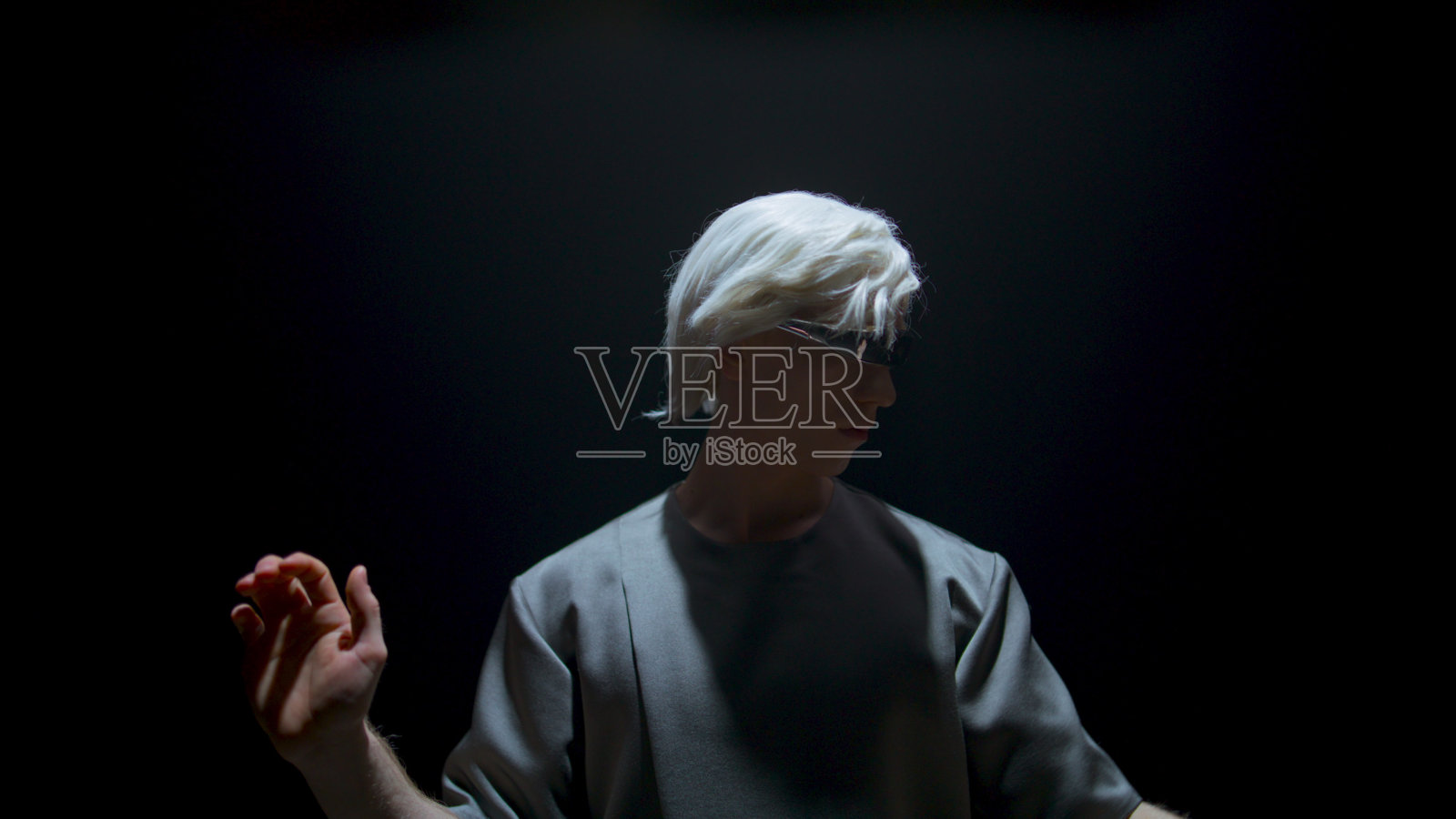 男子在暗室使用虚拟现实耳机。专注的玩家手势触摸无形照片摄影图片