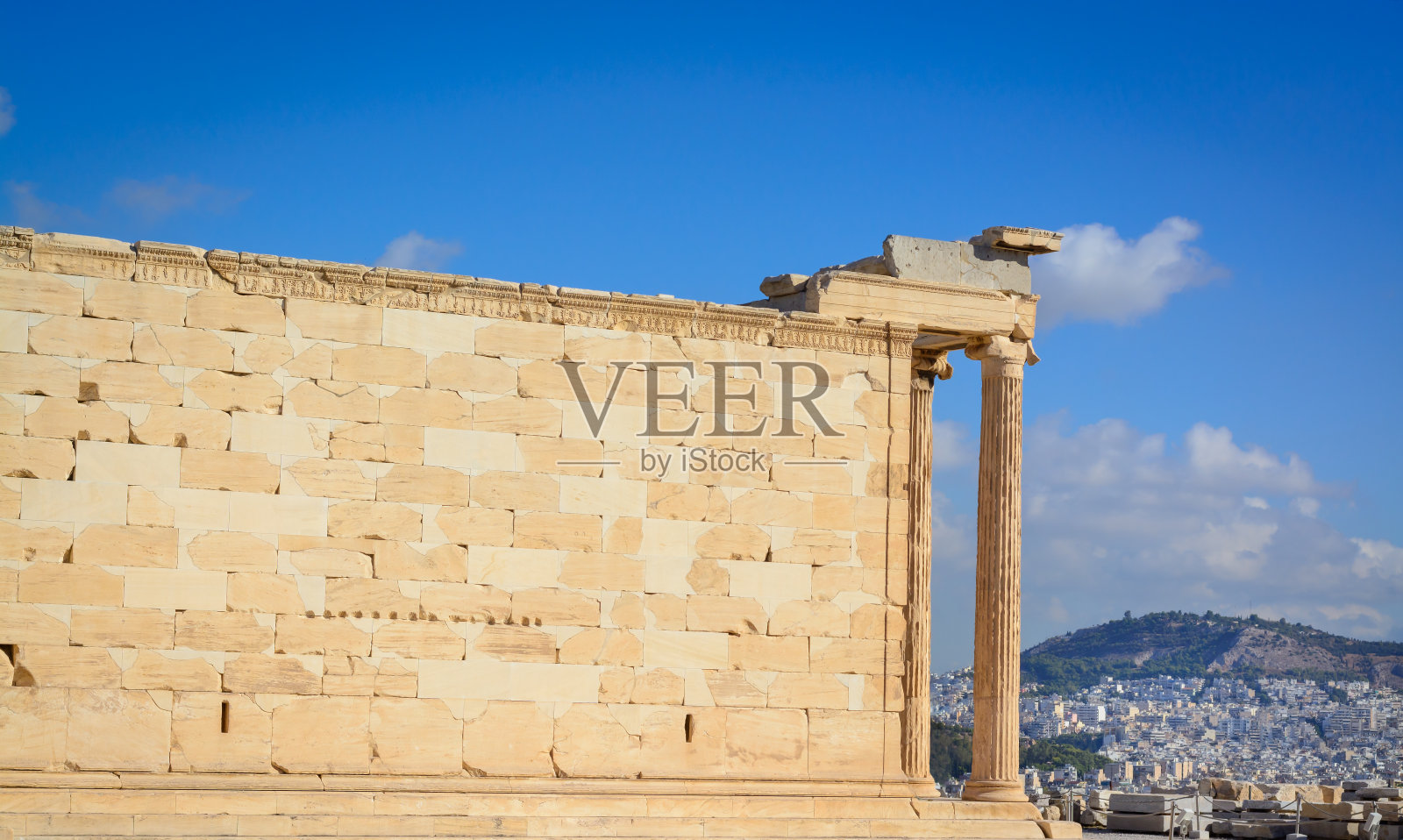 在蓝天的映衬下，卫城山上的埃瑞克提翁神庙的大理石墙壁照片摄影图片