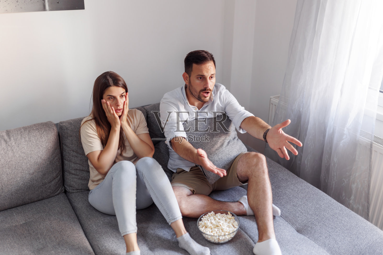 情侣在看电视上的恐怖电影照片摄影图片