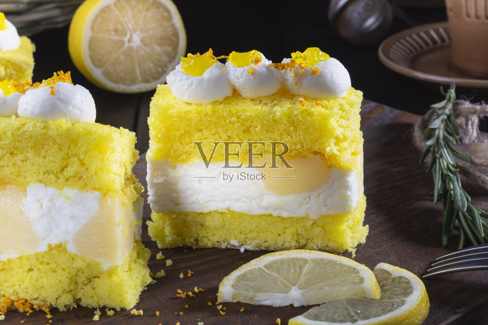 自制柠檬面包片放在质朴的深色木板上。两片柠檬蛋糕饼干，迷迭香照片摄影图片