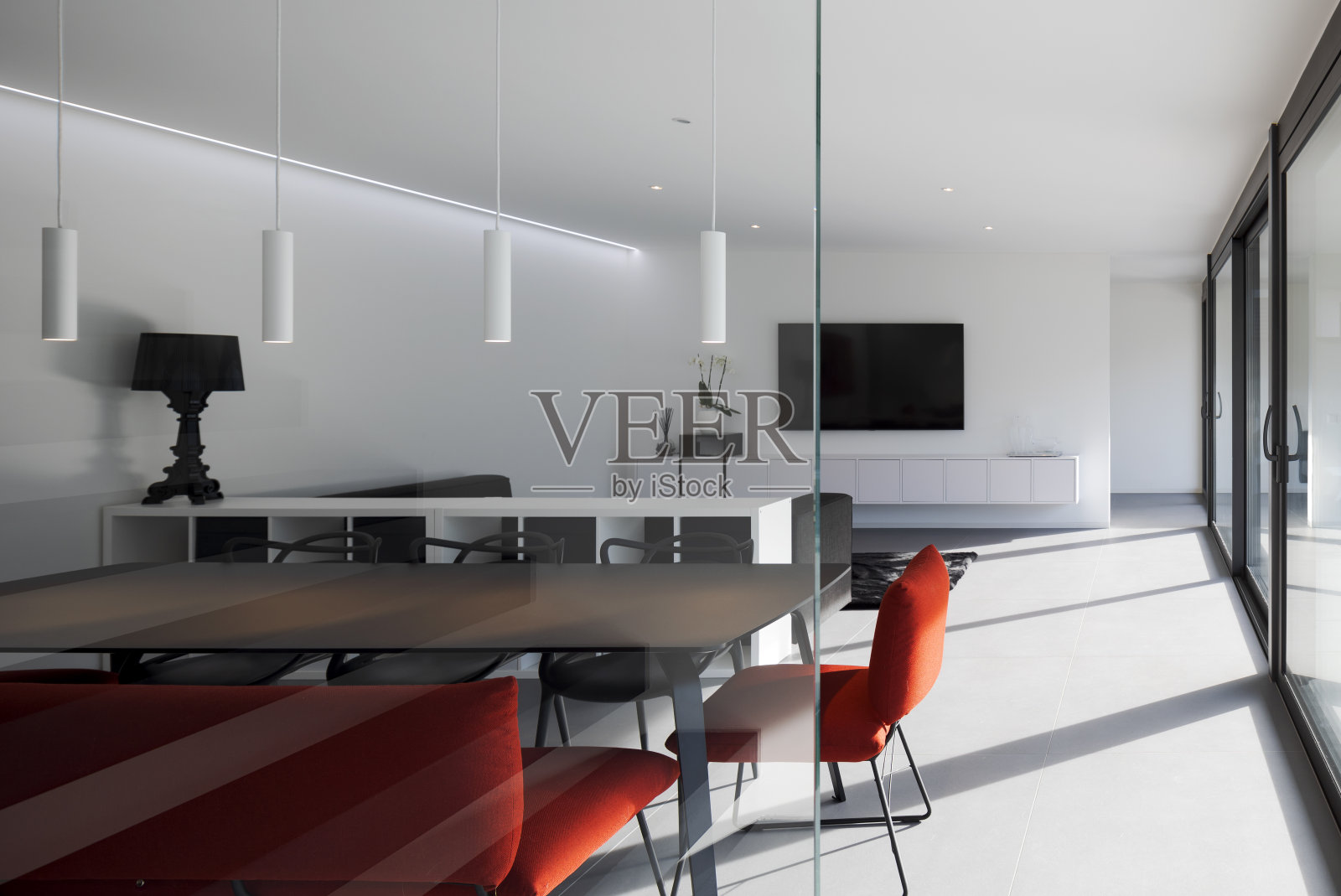 现代客厅细节与扶手椅和红色沙发。阳光透过大窗户照进来。照片摄影图片