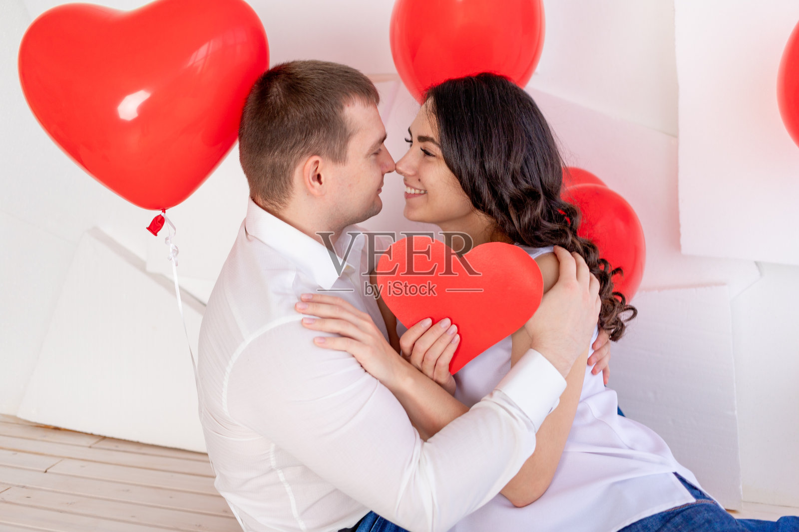 情人节，一个男生和一个漂亮女生用爱的眼神看着对方，里面装着一颗大大的红心照片摄影图片