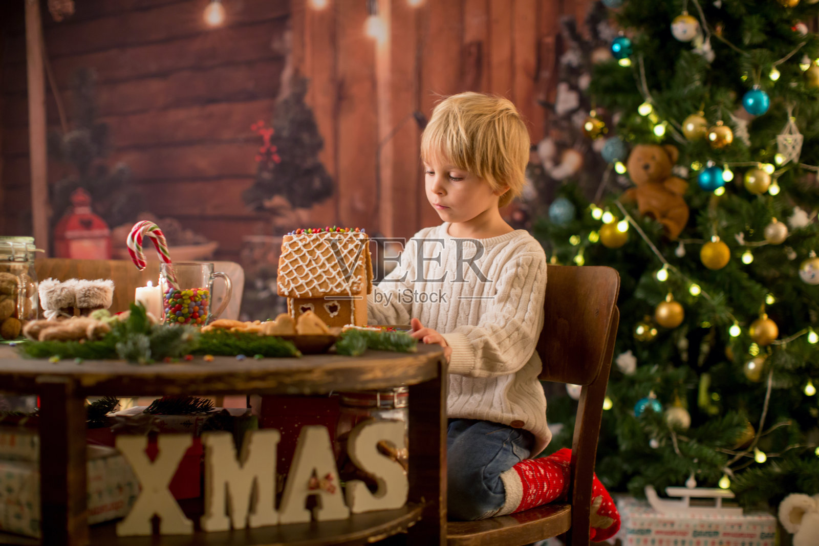 金发幼童，可爱男孩，做圣诞姜饼屋照片摄影图片