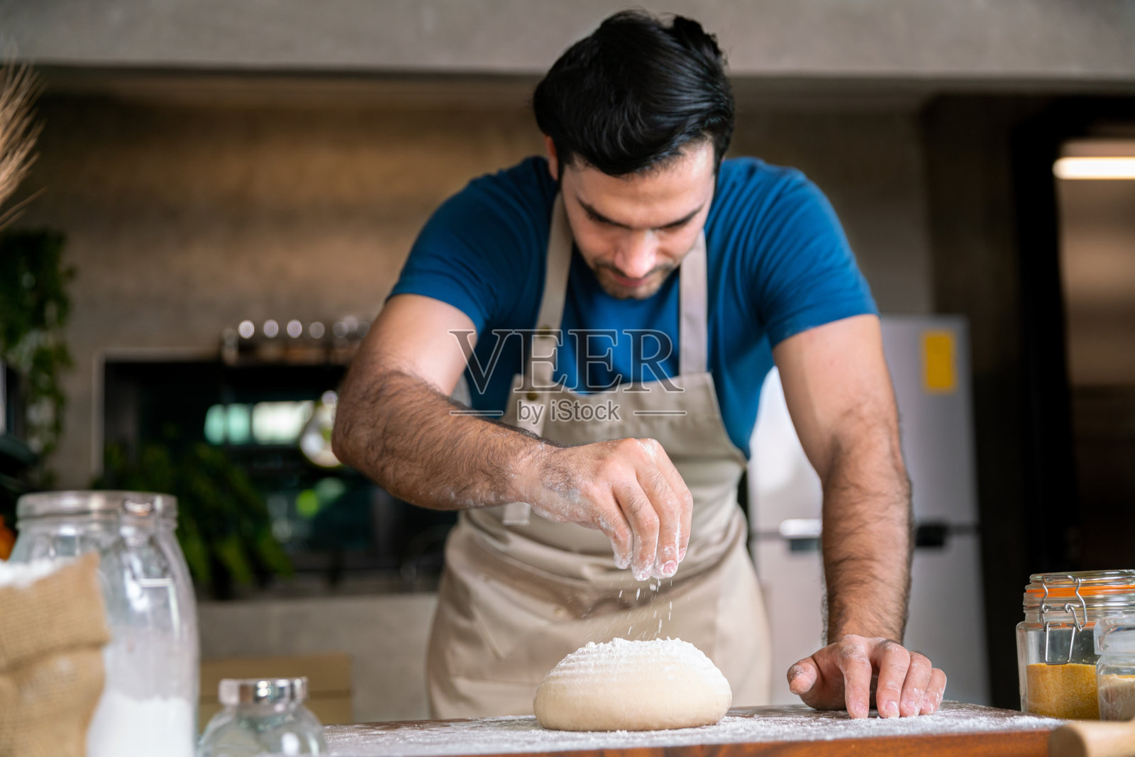 专业厨师在餐厅厨房的木桌上研磨面粉，制作甜点蛋糕和意大利披萨，为您准备特别的快乐美味晚餐照片摄影图片