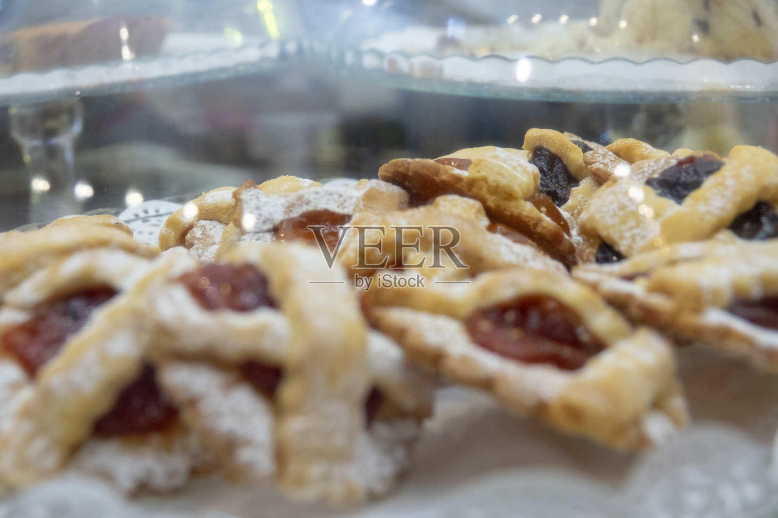 柜台上的玻璃钟下有自制的饼干和馅饼照片摄影图片