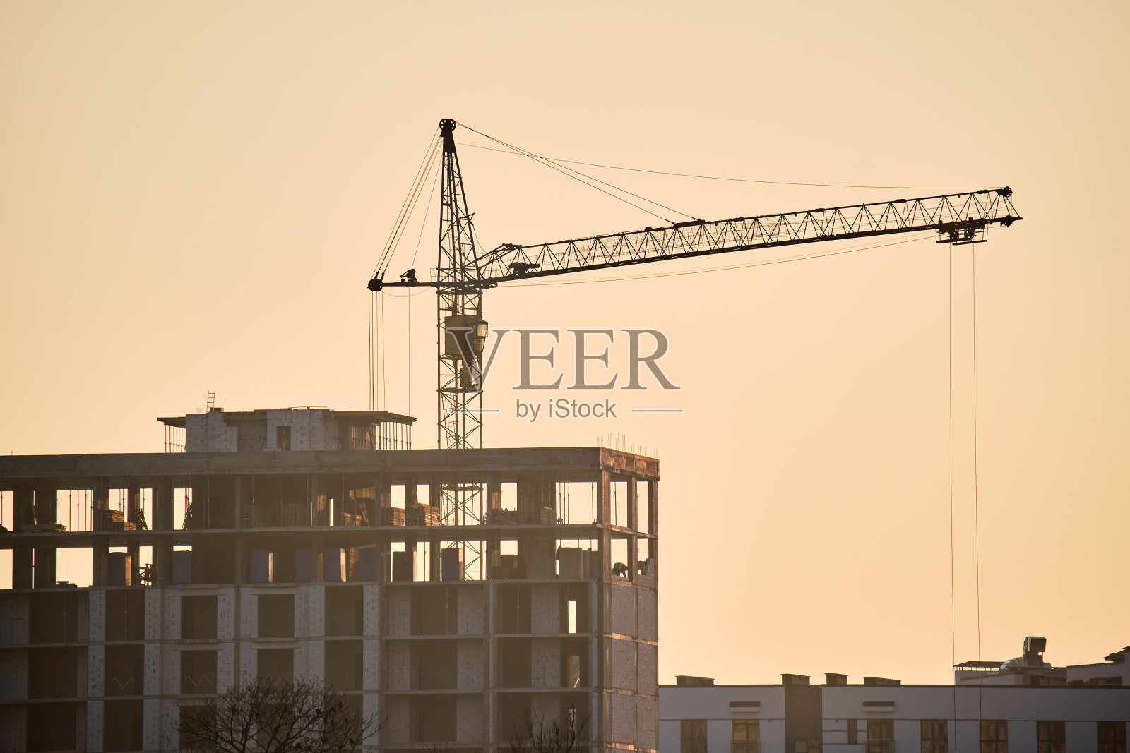 塔吊在高层住宅公寓楼施工现场。房地产开发照片摄影图片