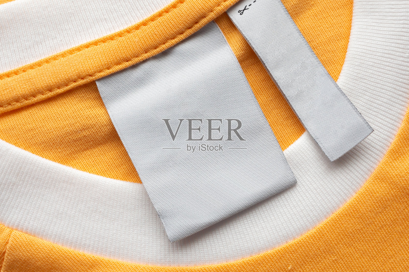 空白白色洗衣护理衣服标签上的黄色织物纹理背景照片摄影图片