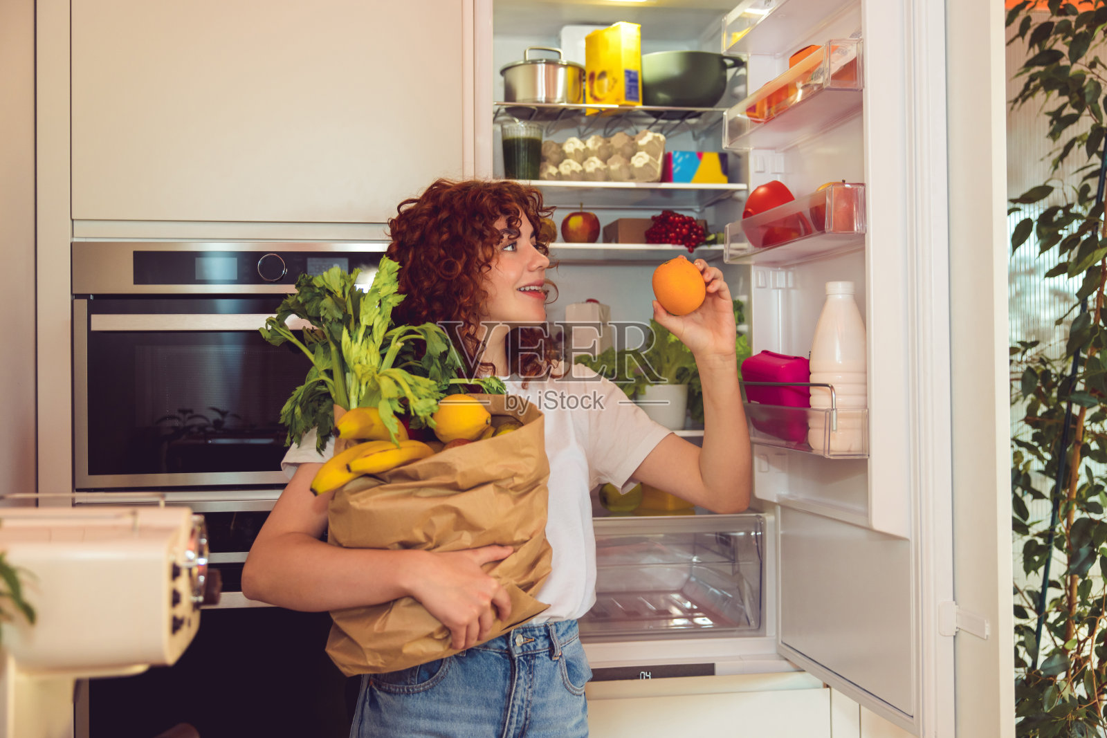 姜色女孩在厨房里打开食物照片摄影图片