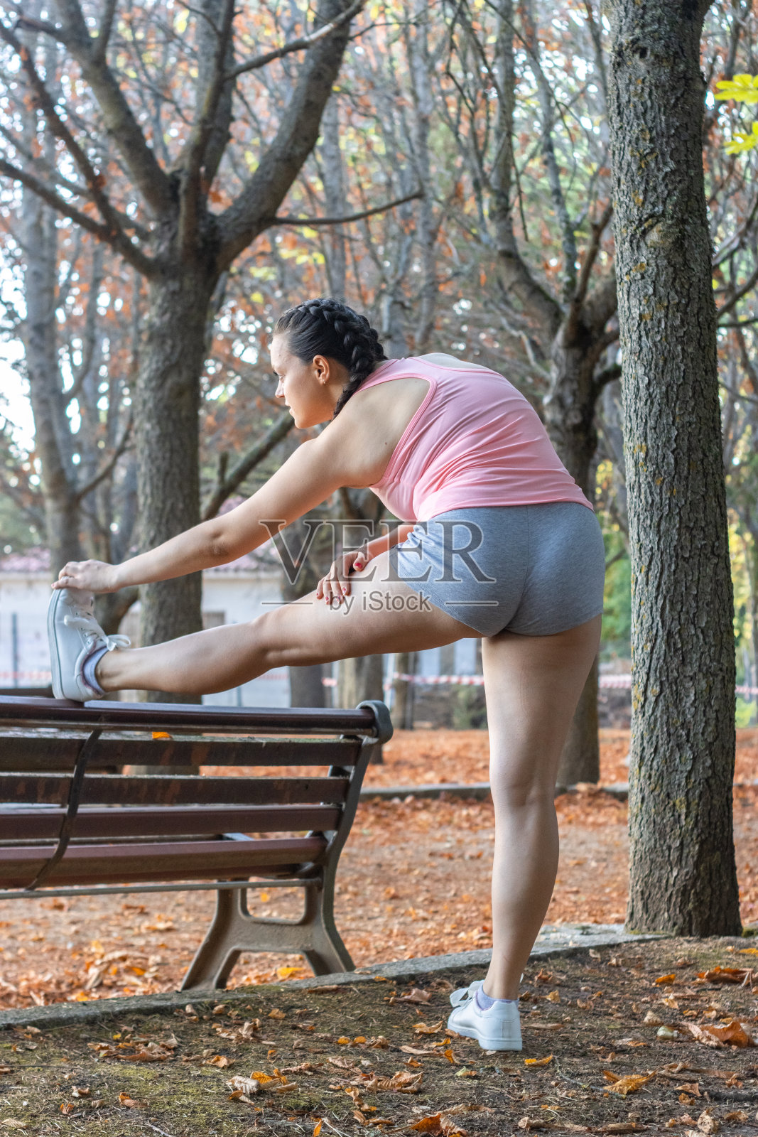 迷人的运动女人在公园里热身。美丽的女孩在公园做热身运动照片摄影图片