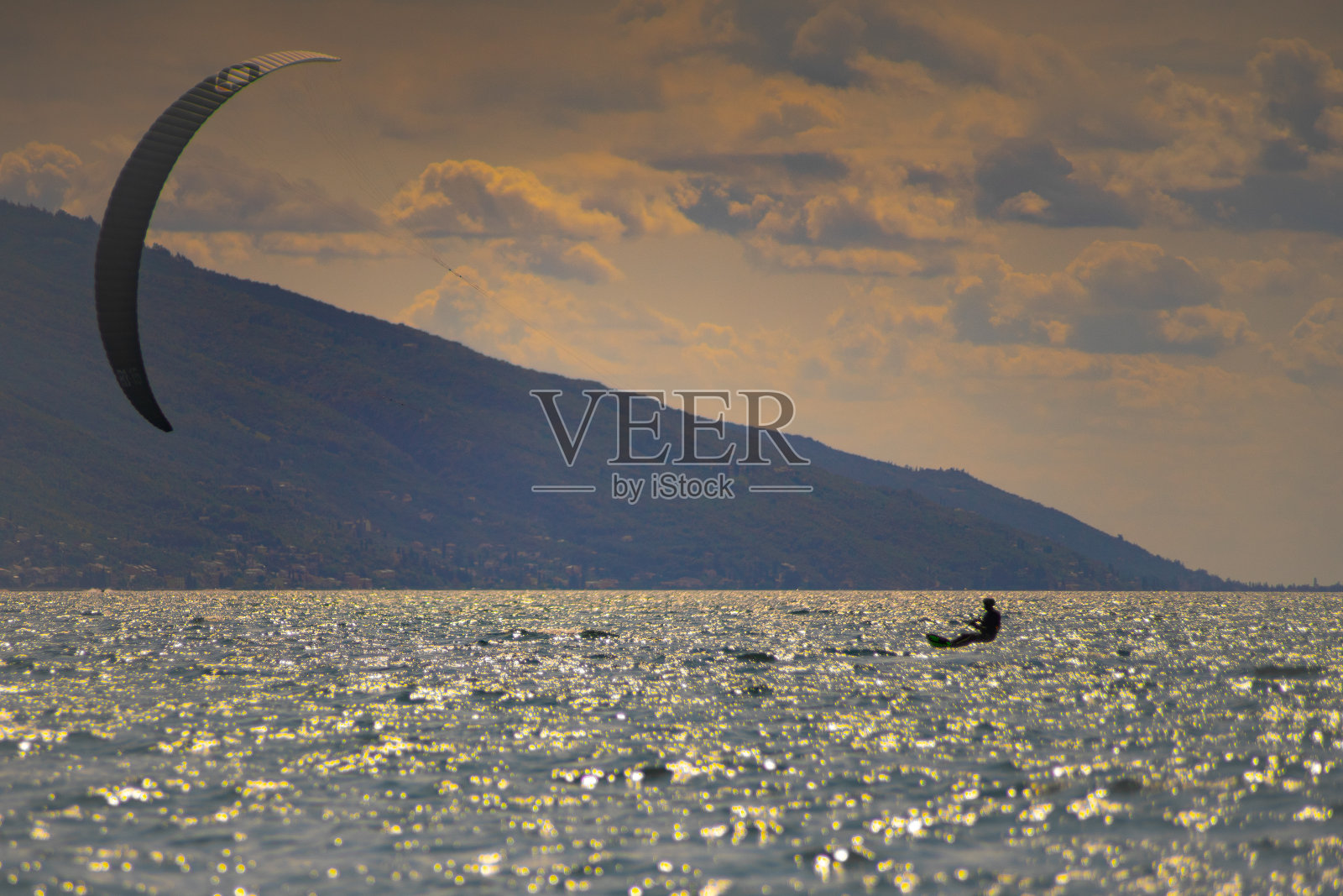 风筝冲浪爱好者在日落表演特技照片摄影图片
